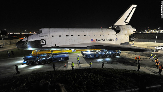 Computer-controlled transporters help move Endeavour across Los Angeles International Airport early Friday. In a trek of about two days, the shuttle will negotiate 12 miles of Southern California's roads and highways for its final resting place at the Los Angeles science museum, NASA officials say.