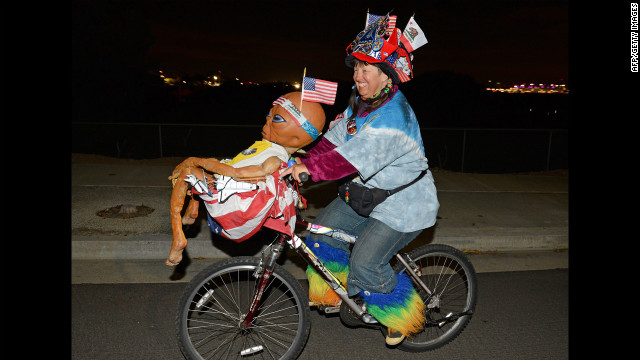 Fan Vivian Robinson rides her bicycle covered in shuttle memorabilia, American flags and an alien doll outside the Los Angeles airport as she waits to see Endeavour.