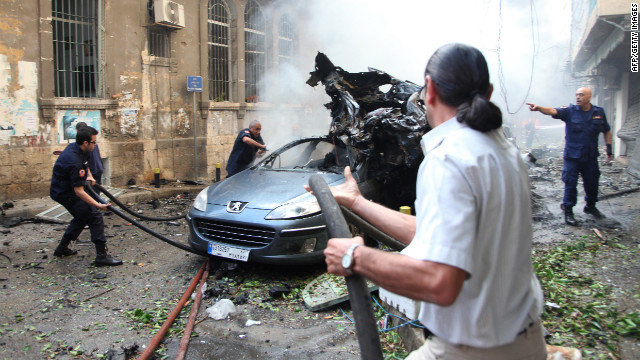 Lebanese firefighters douse burning vehicles.