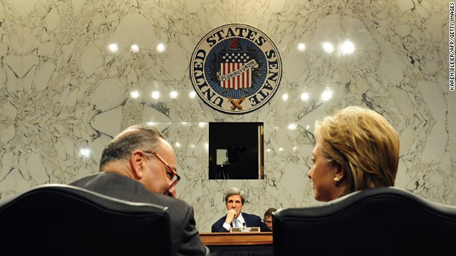 Sen. Charles Schumer, left, looks toward Secretary of State designate Clinton as committee chairman Sen. John Kerry, center, looks on during nomination hearings on January 13, 2009, on Capitol Hill.