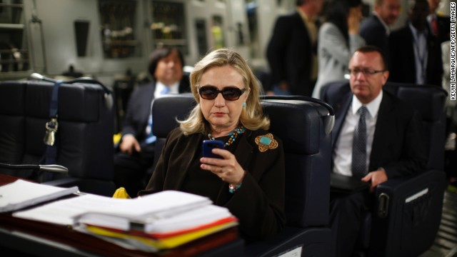 Clinton checks her PDA upon departure in a military C-17 plane from Malta bound for Tripoli, Libya, on October 18, 2011.