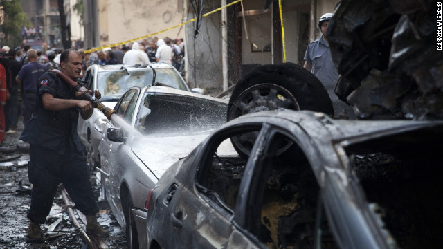 A Lebanese firefighter douses cars at the site of an explosion in Beirut's Christian neighbourhood of Ashrafieh.