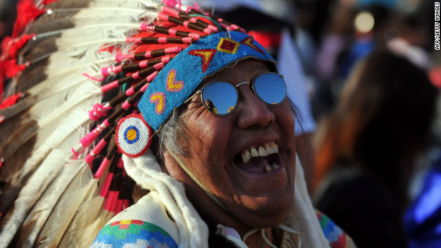 A spectator wearing a Native American headress stands in St. Peter's Square on Sunday.