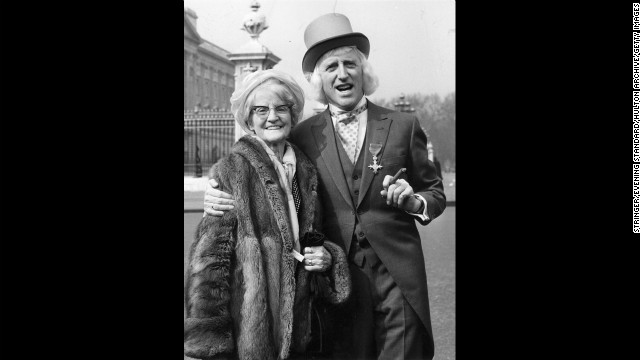 Savile and his mother pose outside Buckingham Palace in London, where he receive his Order of the British Empire in 1972.