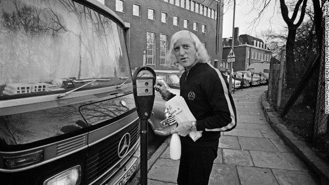 Savile stands on the sidewalk with his motor home.