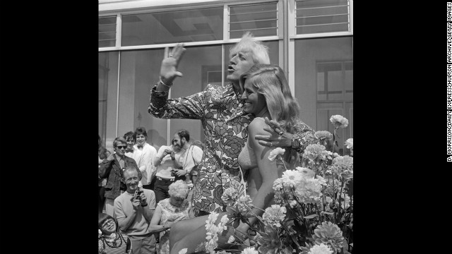 Savile waves with Jersey Holiday Queen Gaynor Lacey at the Jersey Battle of Flowers carnival in 1972.