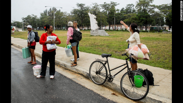 Citizens of Bayamo talk on the sidewalk on Wednesday. 