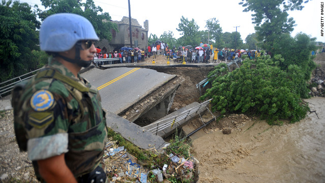 A U.N. peacekeeper on Thursday stands at the edge of a bridge that was washed away by heavy rains from Hurricane Sandy in Port-au-Prince, Haiti.
