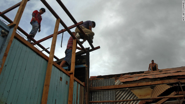 Residents in Bayamo, Cuba, try to fix a house damaged by hurricane Sandy on Thursday.