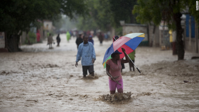 People walk on a flooded street after Hurricane Sandy hit Port Au Prince, Haiti, on Thursday.