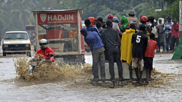 A motorcyclist rides through a flooded street Friday in Petit-Goâve, Haiti, where three overflowing rivers put homes and farms under water.