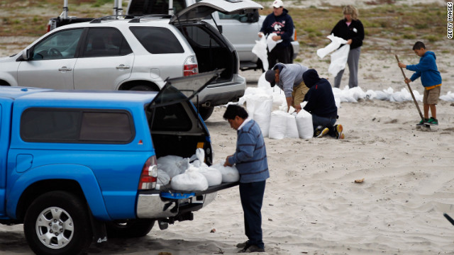 Residents of Long Beach, New York, fill sandbags on Sunday in preparation for the storm.