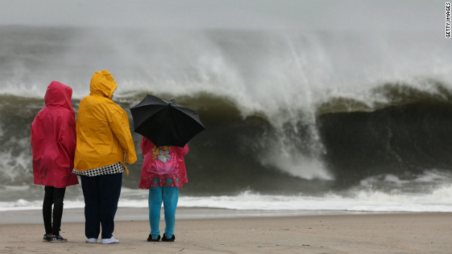 People stand on the beach watching the heavy surf caused by the approaching Hurricane Sandy, on Sunday, October 28, in Cape May, New Jersey. Hurricane Sandy is expected to hit the New Jersey coastline sometime on Monday, bringing heavy winds and floodwaters.