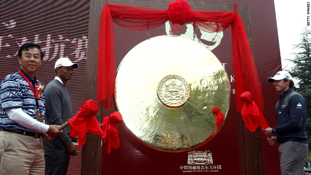 Rory McIlroy and Tiger Woods look on in amusement before banging a ceremonial gong to mark the start of their "Duel at Jinsha Lake." 