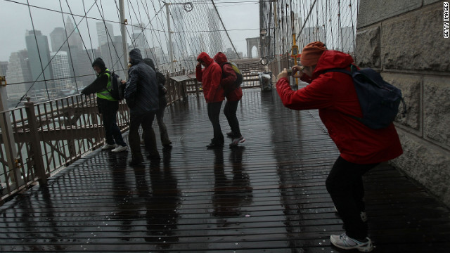 People pose for pictures on the Brooklyn Bridge on Monday.