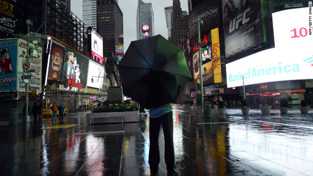 A lone tourist stands in Times Square early Monday as New Yorkers brace against Hurricane Sandy.