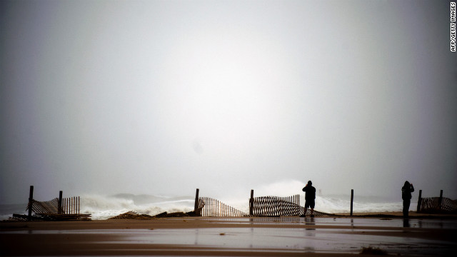 Two people stand near the edge of the boardwalk on Monday in Ocean City, Maryland.
