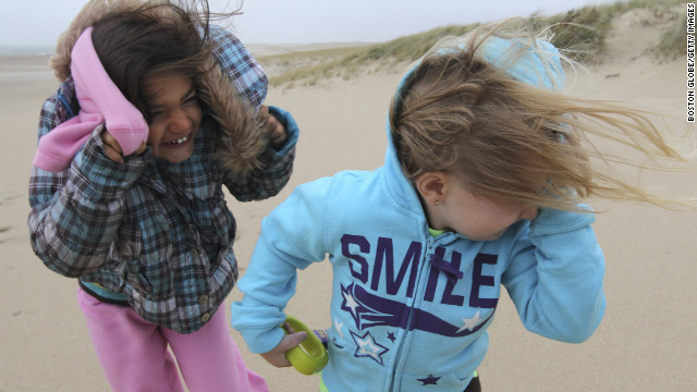 Jillian Webb, left, and Arianna Corso are pelted by wind and sand on Lighthouse Beach in Chatham, Massachusetts, on Monday.