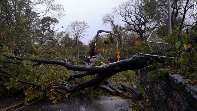 Workers clear a tree blocking East 96th Street in Central Park in New York on Tuesday. 