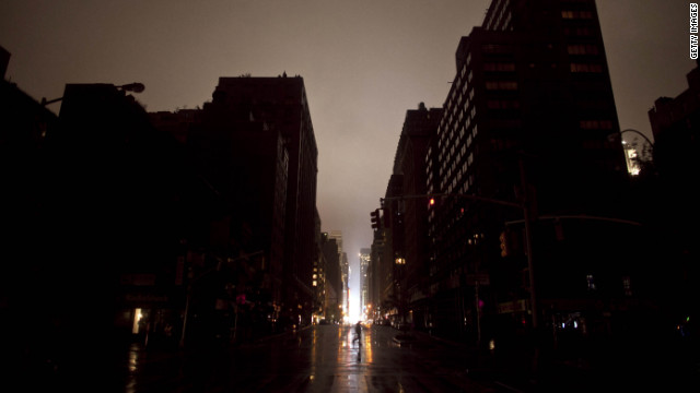 A pedestrian walks across a New York street where the power was out late Monday, October 29. The storm surge set records in Lower Manhattan, where flooded substations caused a widespread power outage. <a href='http://www.cnn.com/2012/10/25/americas/gallery/weather-sandy/index.html'>See more photos of Sandy's destructive path.</a>