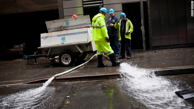 Con Edison employees monitor the drainage of water being pumped out of Seven World Trade Center in the Financial District of New York on Tuesday.