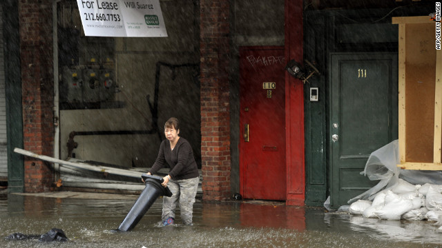 A woman wades through water at the South Street Seaport in New York City on Tuesday.