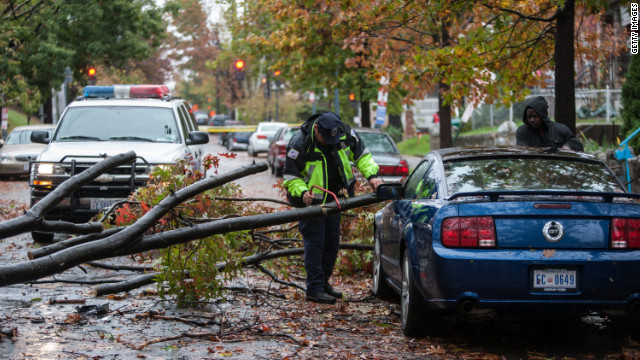 A police officer helps remove a tree branch brought down during the storm in Washington on Tuesday.
