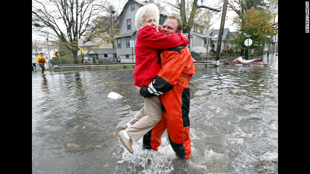 An emergency worker carries a resident through floodwaters in Little Ferry, New Jersey, on Tuesday.