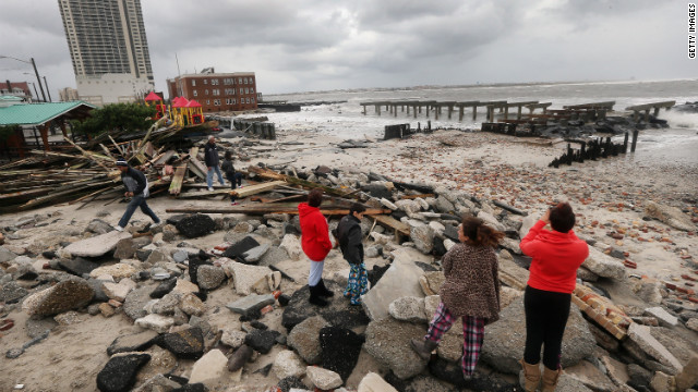 People stand among the debris of the destroyed section of Atlantic City, New Jersey's, uptown boardwalk on Tuesday.