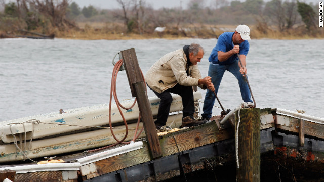 Ted Wondsel, left, of Point Lookout works on part of a dock destroyed in the storm in Long Beach on Tuesday.