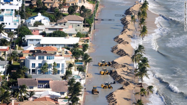 Work crews push sand from a roadway in Fort Lauderdale, Florida, due to storm surge related to flooding on Monday.