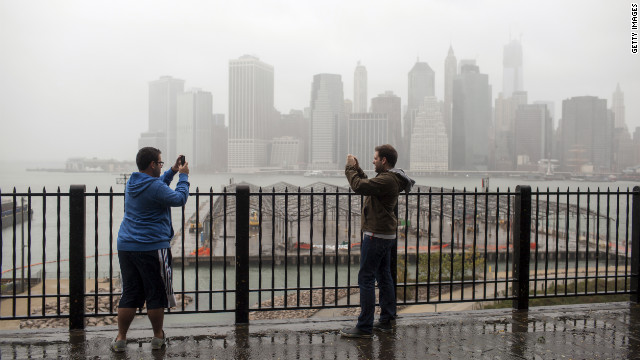 Two people shoot video along Brooklyn Heights' Promenade on Monday as Sandy approaches landfall.