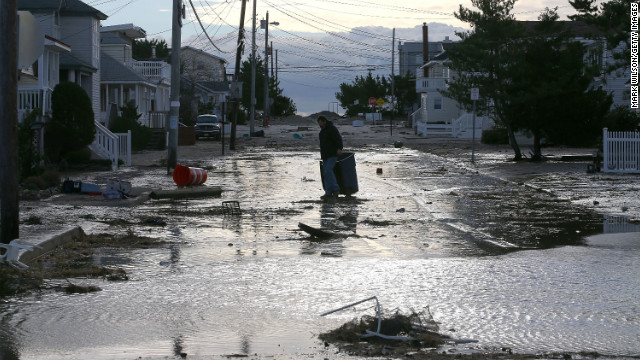 A man makes his way through floodwater and debris in Long Beach Island, New Jersey, on Wednesday.