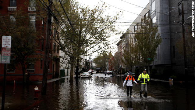 Residents traverse flooded streets as clean up operations begin in Hoboken, New Jersey.