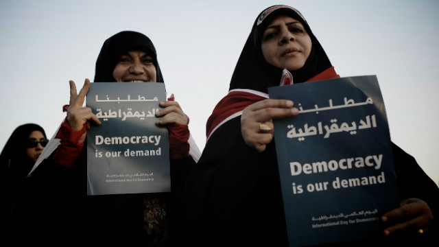 Bahraini Shiite Muslim women hold signs during an anti-government rally in the village of Shakhora on September 14, 2012.