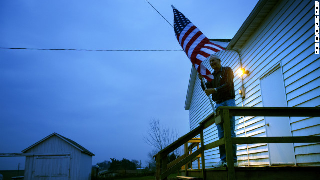 Election inspector Jim Nodorft prepares to hang the U.S. flag outside the Smelser Town Hall as polls opened at 7 a.m. in Georgetown, Wisconsin.