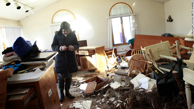 A woman sifts through her mother's damaged home for items to save Sunday in the Breezy Point neighborhood of Queens, New York.