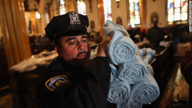 A police officer carries blankets donated by Ikea for people affected by Superstorm Sandy in Brooklyn.