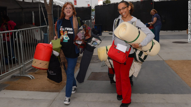 Two people arrive at tent city ready to set up camp.