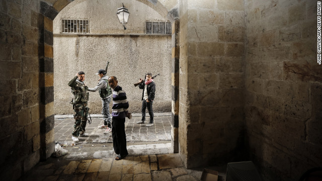 Syrian opposition fighters pass a civilian as they patrol the northern city of Aleppo on Sunday.