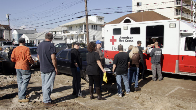 Residents who returned to their damaged homes line up for a hot meal served from a Red Cross vehicle on Samson Avenue in Seaside Heights, New Jersey, on Monday.