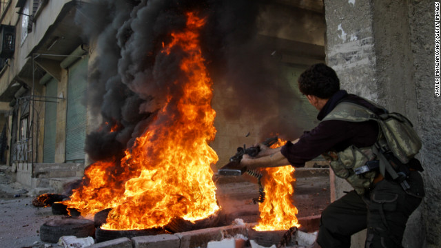 Smoke billows from burning tires as a Syrian rebel fires toward regime forces in Aleppo on Tuesday.