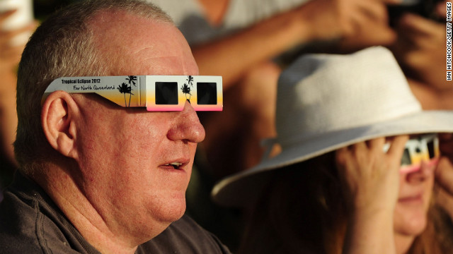 A spectator views the solar eclipse through special eclipse viewing glasses in Palm Cove on Wednesday.