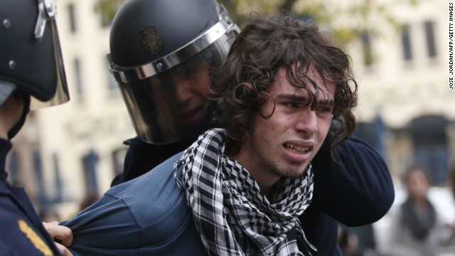 Riot policemen arrest a protester in Valencia on November 14, 2012 during a general strike.