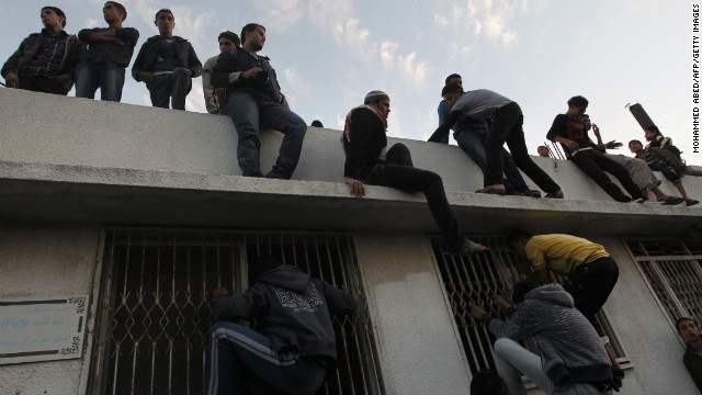 Palestinian youths look inside a building where al-Jaabari's body was brought after the attack.