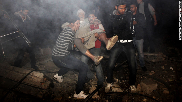 Palestinian youths evacuate an elderly man following an Israeli airstrike.