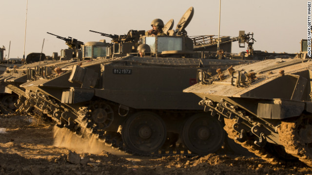 Israeli soldiers rest by their armored personnel carriers stationed on the Israel-Gaza border on Thursday, November 15.