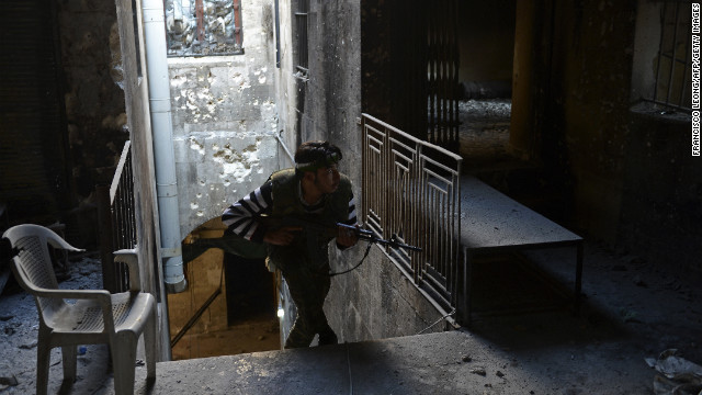 A Syrian rebel takes cover during fighting against Syrian government forces in Aleppo on November 15, 2012.