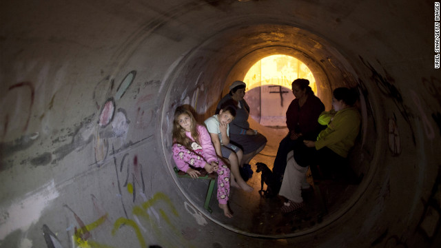 Israelis take cover in a lpipe used as a bomb shelter, after a rocket was launched from the Gaza Strip on Thursday, November 15 in Kiryat Malachi, Israel. Rockets and shells crisscrossed between Israel and Gaza on Thursday as Palestinian militants continued rocket attacks on Israeli civilians and Israel pounded what it called terror sites. 