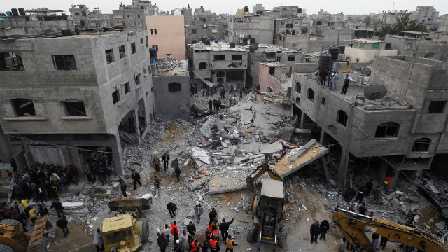 Palestinians gather at the site of an Israeli air raid in Gaza City on November 17, 2012. Israeli air strikes hit the cabinet headquarters of Gaza's Hamas government after militants fired rockets at Jerusalem and Tel Aviv as Israel called up thousands more reservists in readiness for a potential ground war.